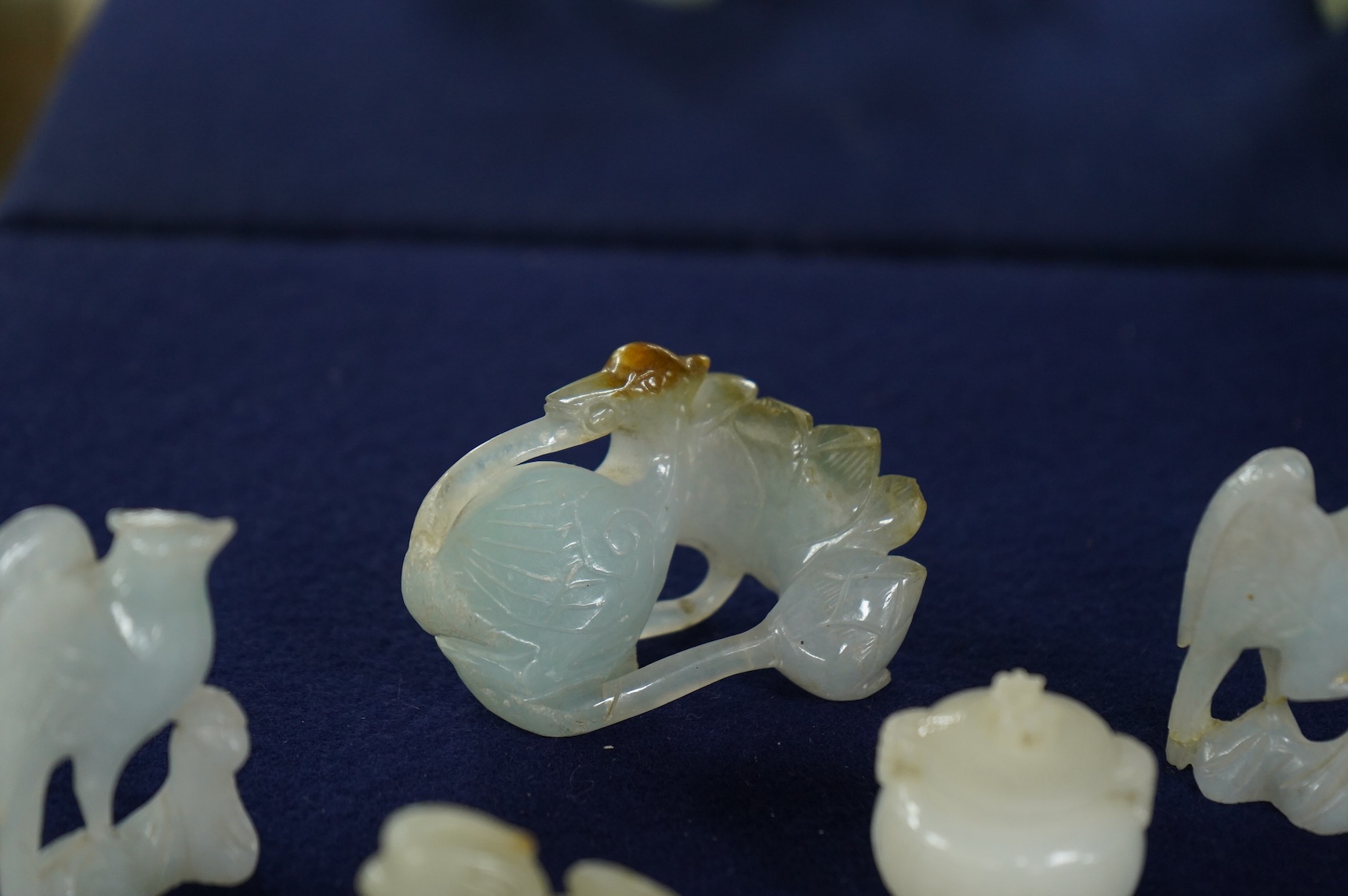 A Chinese jade figure of a Mandarin duck and a miniature pot and cover, three jadeite carvings and a bowenite dragon, 16.5cm